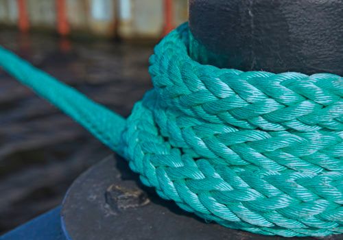 Mooring bollard with nautical rope knotted on it